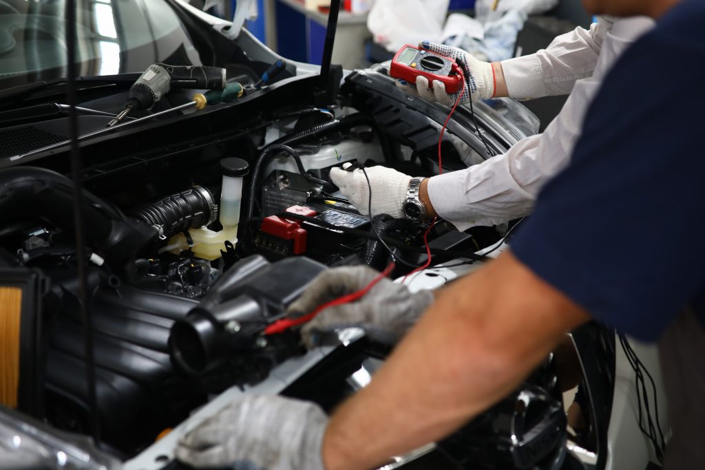 Two specialists of service for repairing wiring Two specialists of service for repairing wiring and computer diagnostics car solve problem engine malfunction. Serviceman collaborate education training concept. New technology studyng